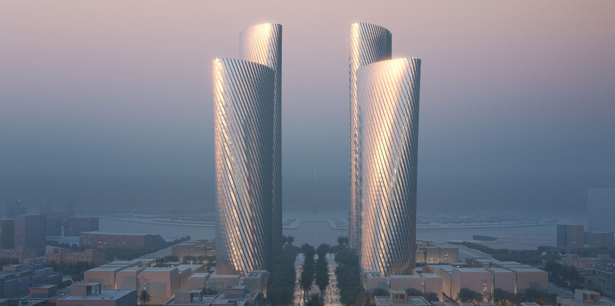 Four twisting Lusail Towers rising above their low-rise podium buildings